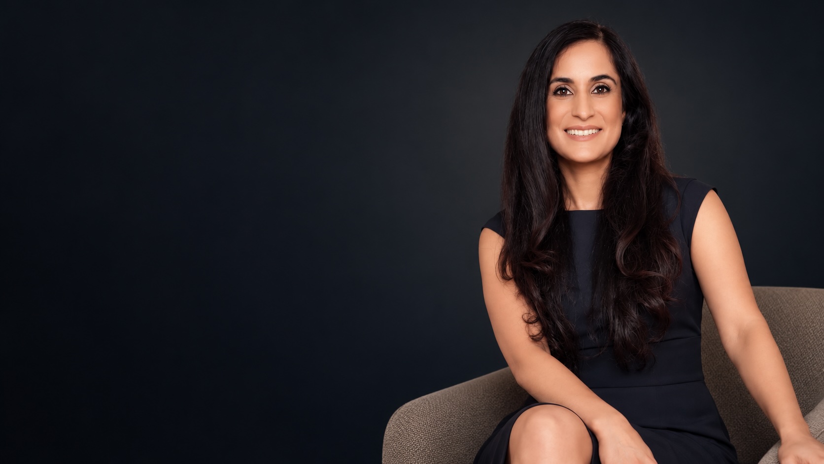 Dr. Remina Panjwani smiling, seated in a navy dress
